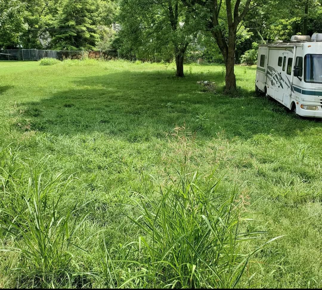 A white rv is parked in a grassy field.