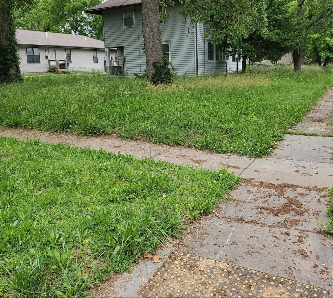 A sidewalk leading to a house with a lot of grass
