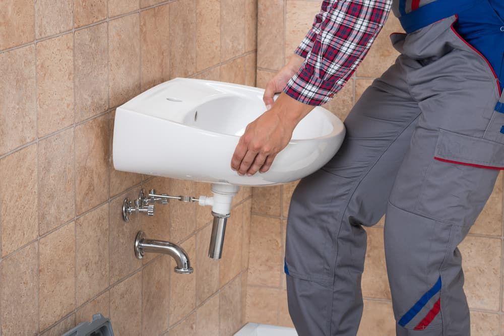 Plumber Is Installing A Sink In A Bathroom — Russell Plumbing In Manunda, QLD