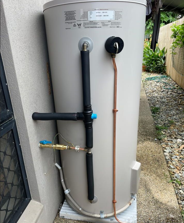A Water Heater Is Sitting On The Side Of A Building — Russell Plumbing In Manunda, QLD