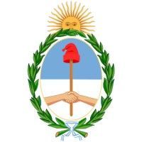 Escudo de armas de Argentina con sol naciente, corona de laurel verde, manos y lanza roja sobre escudo azul y blanco.