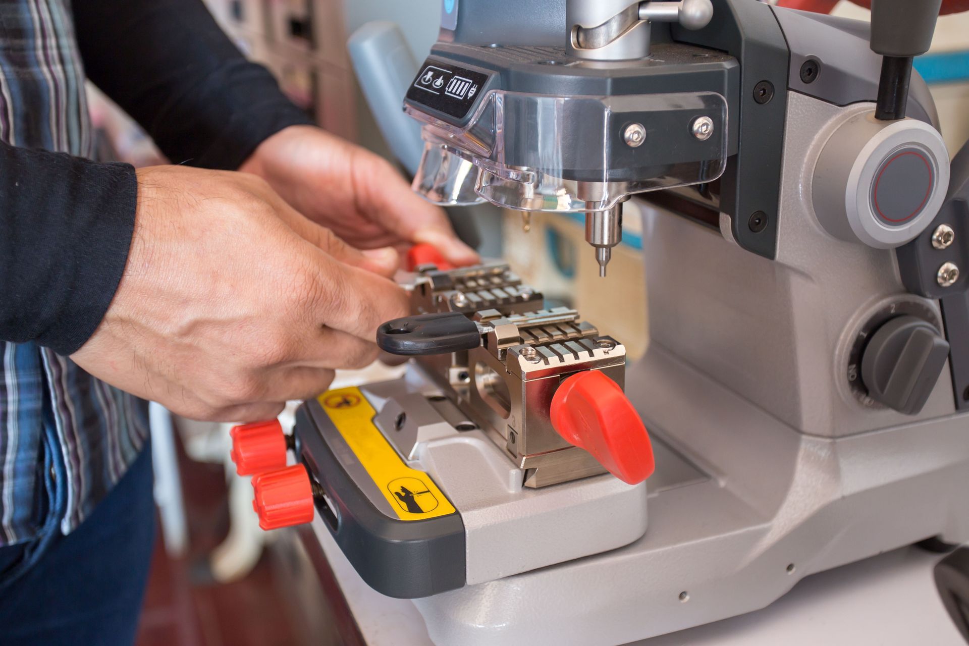 A man is using a key cutting machine to make keys.