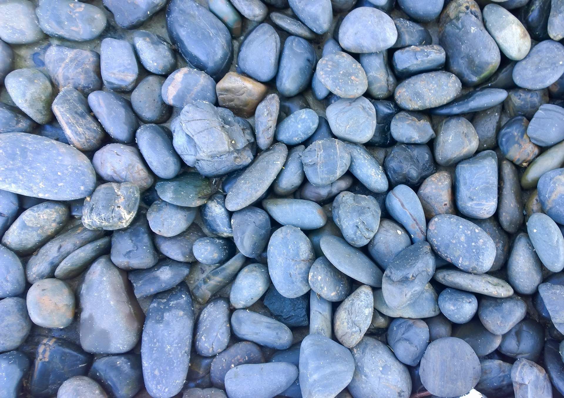 A pile of blue rocks is sitting on the ground.