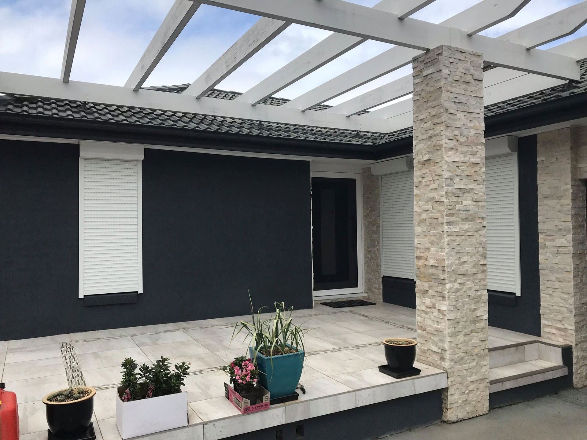 Modern Patio With Pergola, Stone Column and Potted Plants — Douglass Blinds & Security Screens in Wagga Wagga, NSW