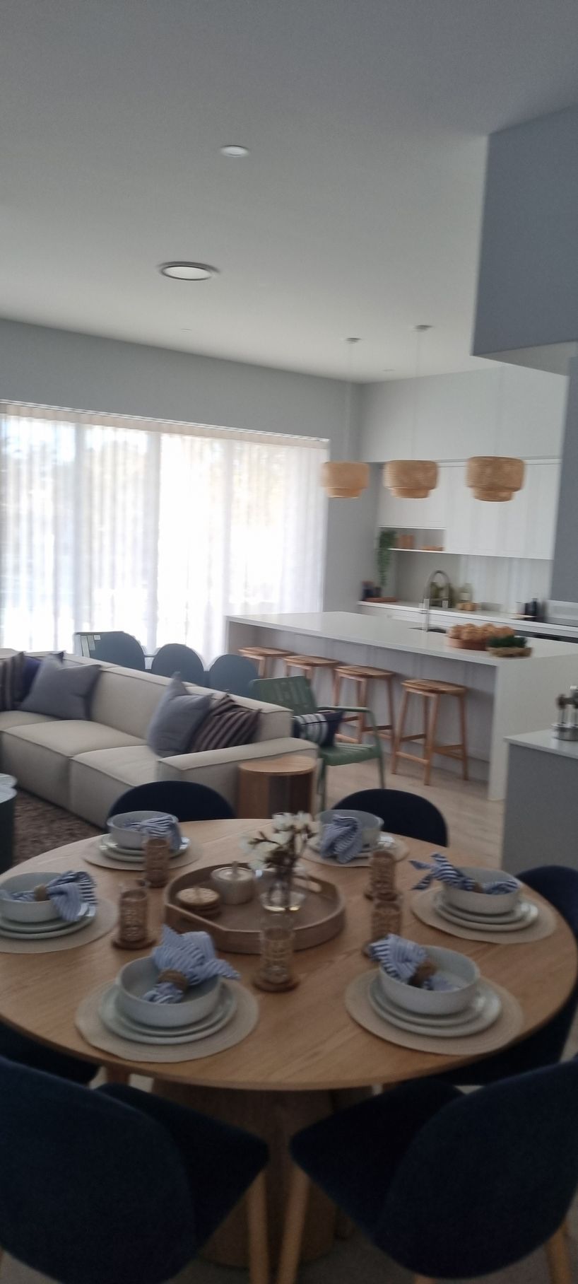A Dining Area With a Round Wooden Table Set for a Meal — RWM Cleaning in Deception Bay, QLD