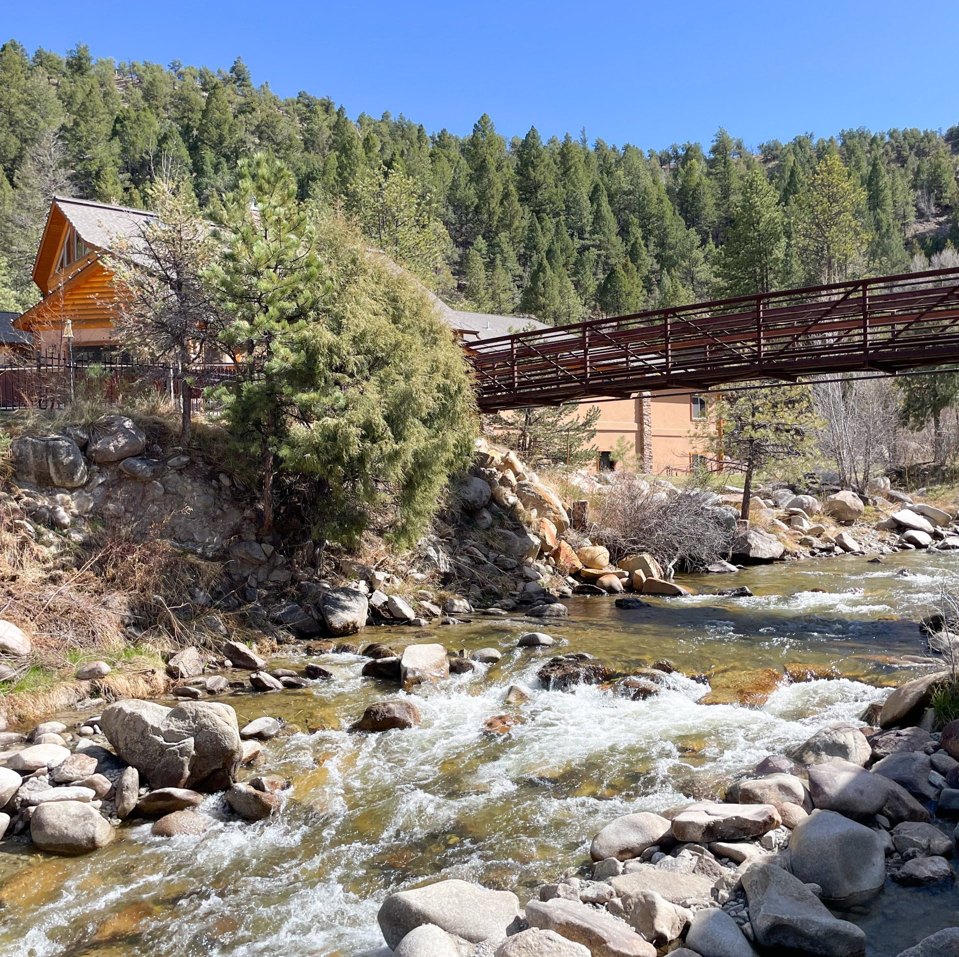 View of Chalk Creek and the pedestrian bridge connecting the hotel guests/adults only pools to the family friendly pools