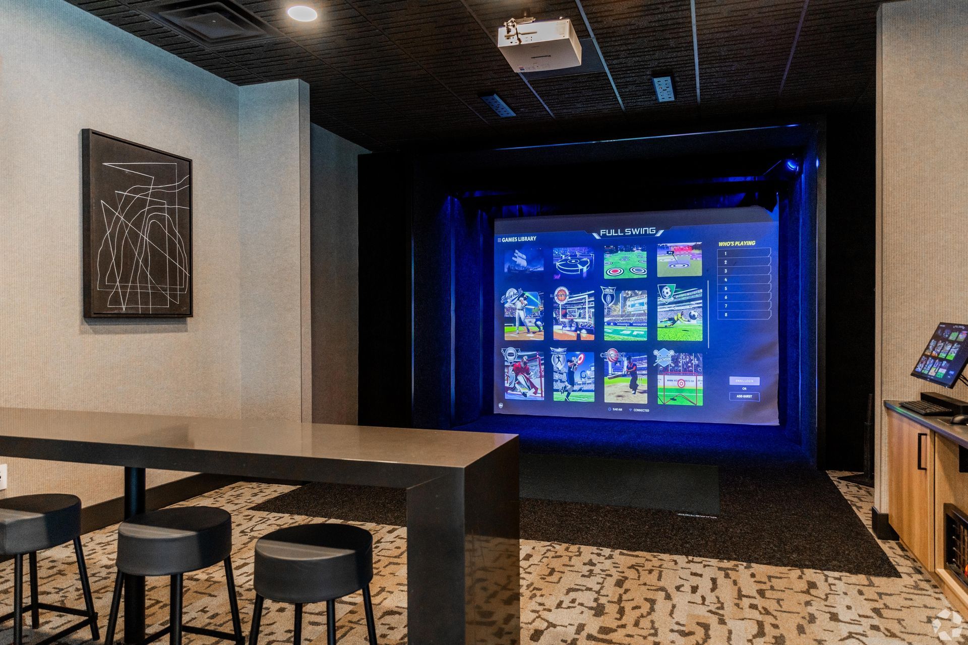 19th and Graf  Apartments A recreational room with a large screen displaying sports, a bar table, stools, and a projector.