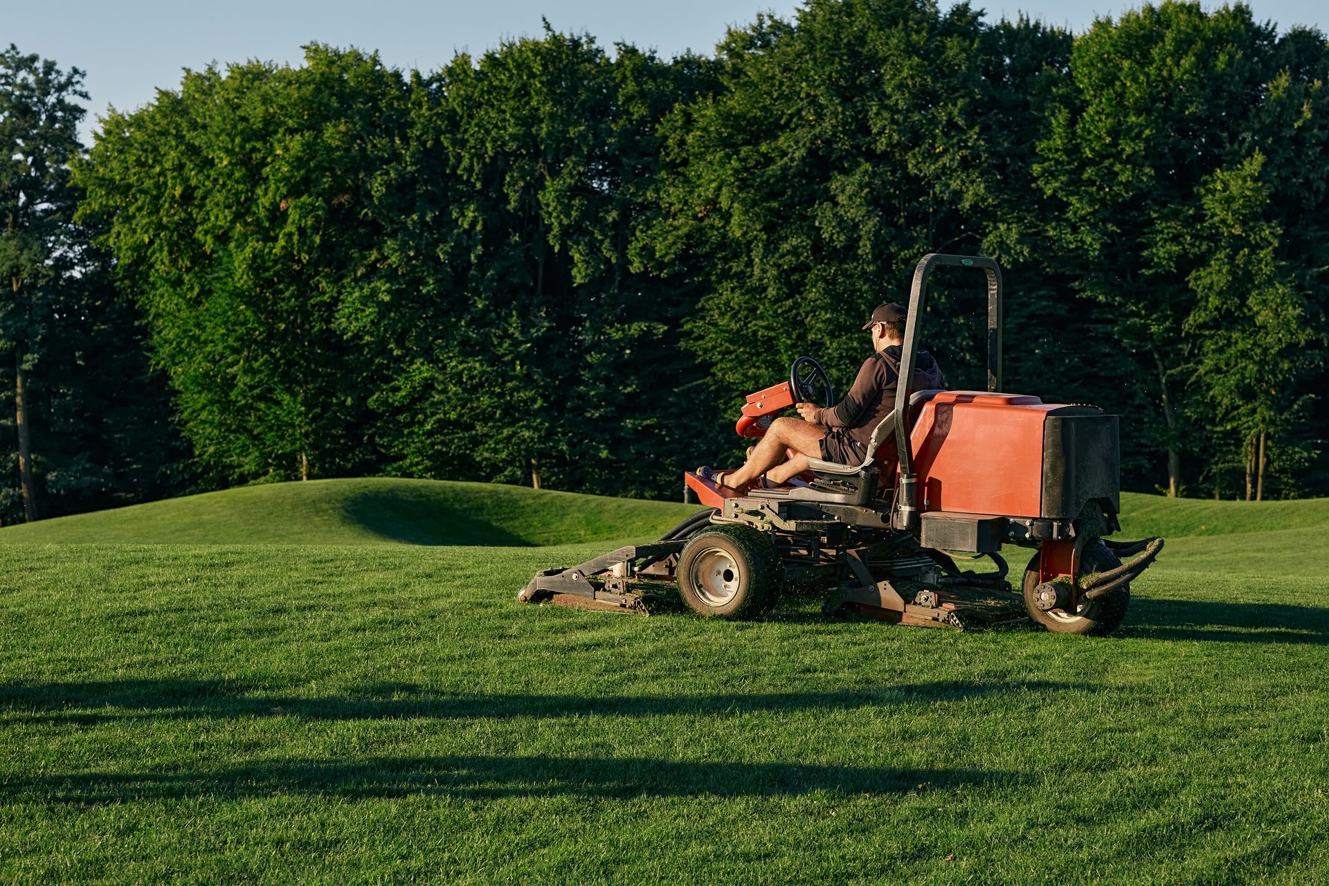 Commercial lawn maintenance worker mowing a professionally maintained property