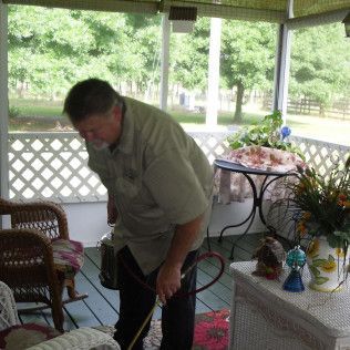 Man spraying a screened porch, with a can in his hand.