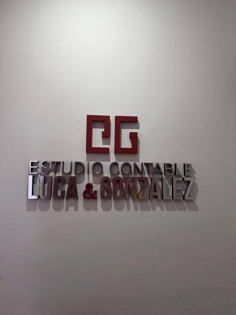Escritorio de oficina en casa con ordenador, calculadora, lámpara, teclado, ratón y montones de papeles