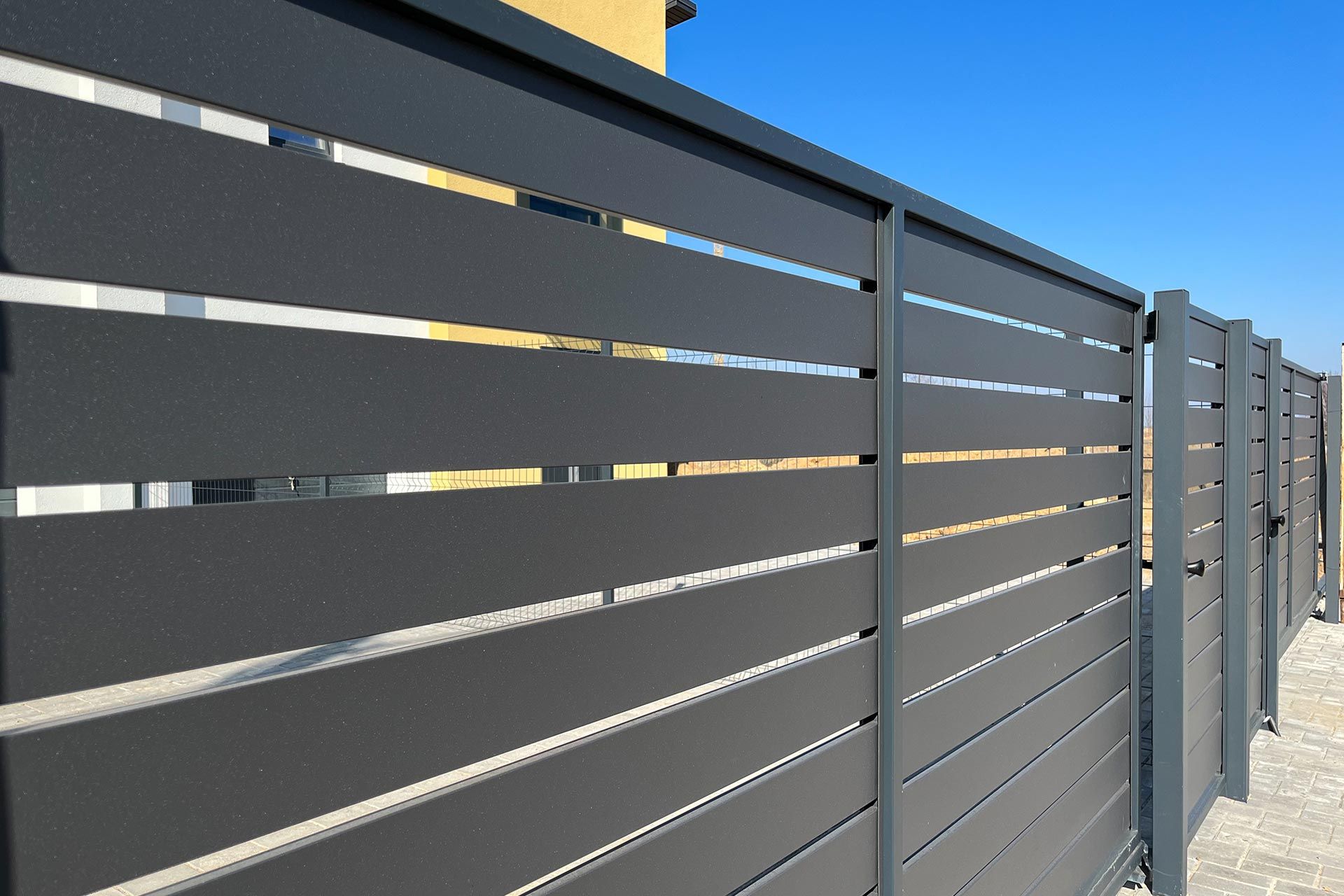 Modern metal fence for fencing the yard area. Horizontal sections of the fence made of metal. Modern metal fence for fencing the yard area. Horizontal sections of the fence made of metal.