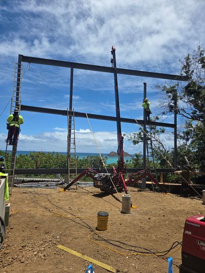 Lopey's mini crane lifting steel beams for a new home frame on Oahu