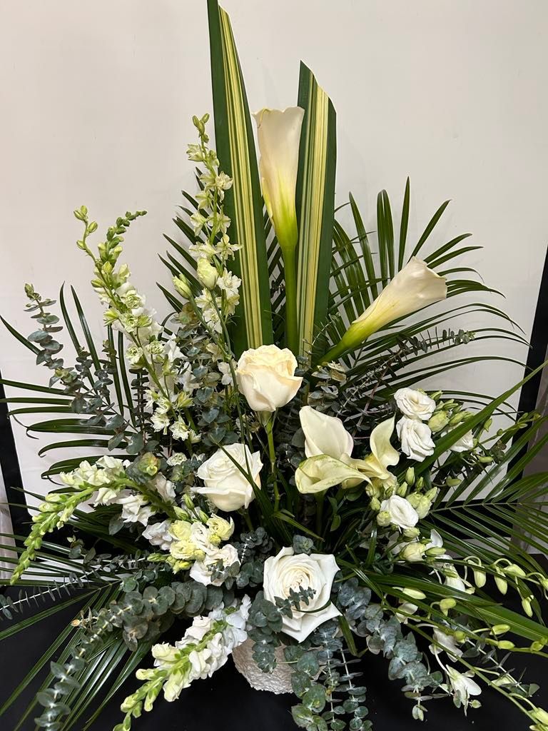 Un grand bouquet de fleurs blanches et de verdure sur une table.