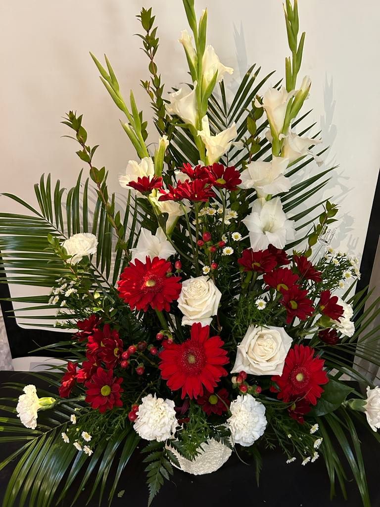 Un bouquet de fleurs rouges et blanches est posé sur une table.
