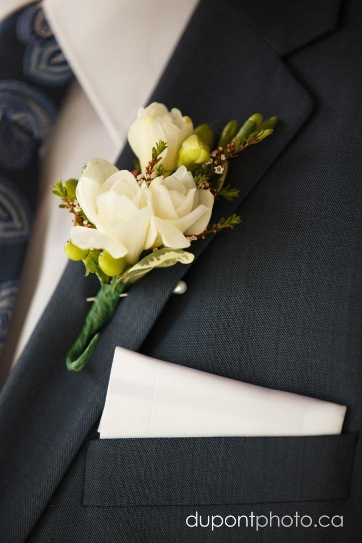 Un homme en costume a une fleur dans sa poche