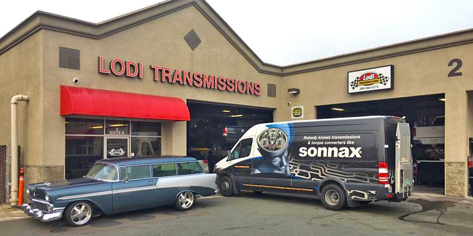 A classic car and a van with