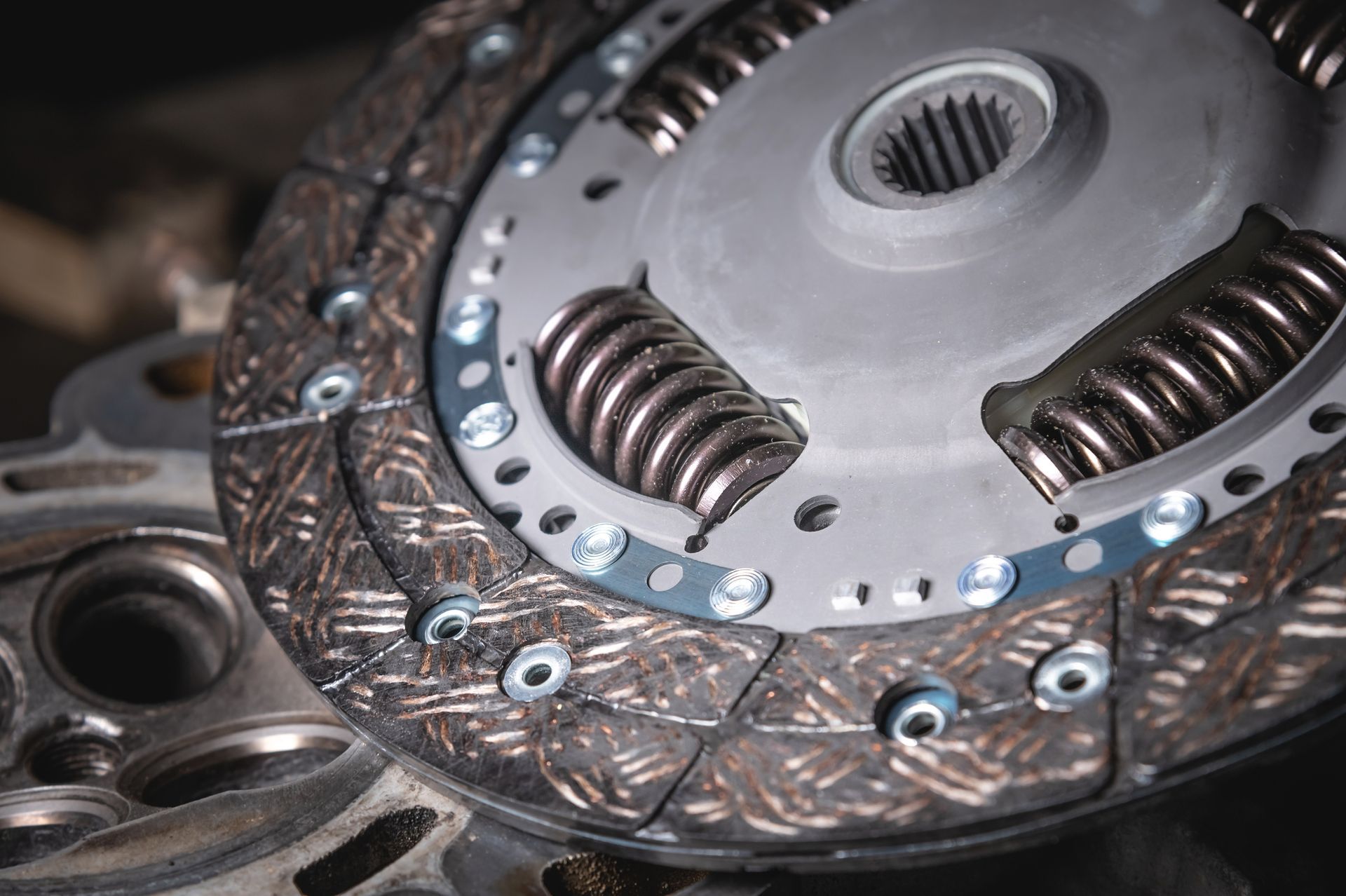 Close-up of a car clutch disc with springs and friction material, showing details of the mechanical components.