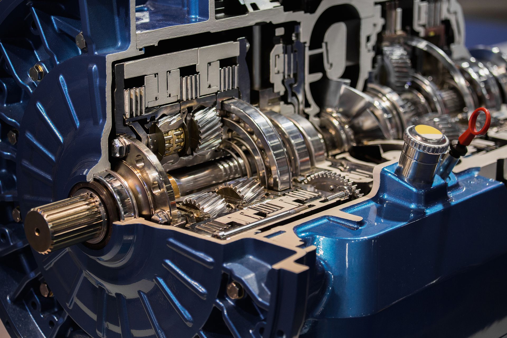 Cross-section of an automatic transmission, showcasing internal gears and components in a blue casing.