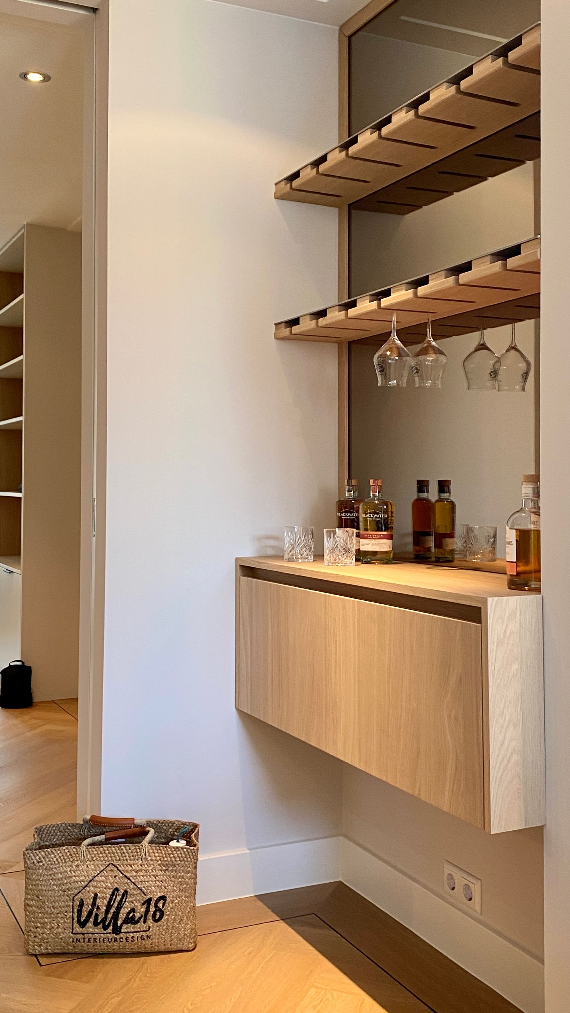 Maatwerk dranken kast met houten planken, hangende glazen en een licht houten kastje eronder | Villa18