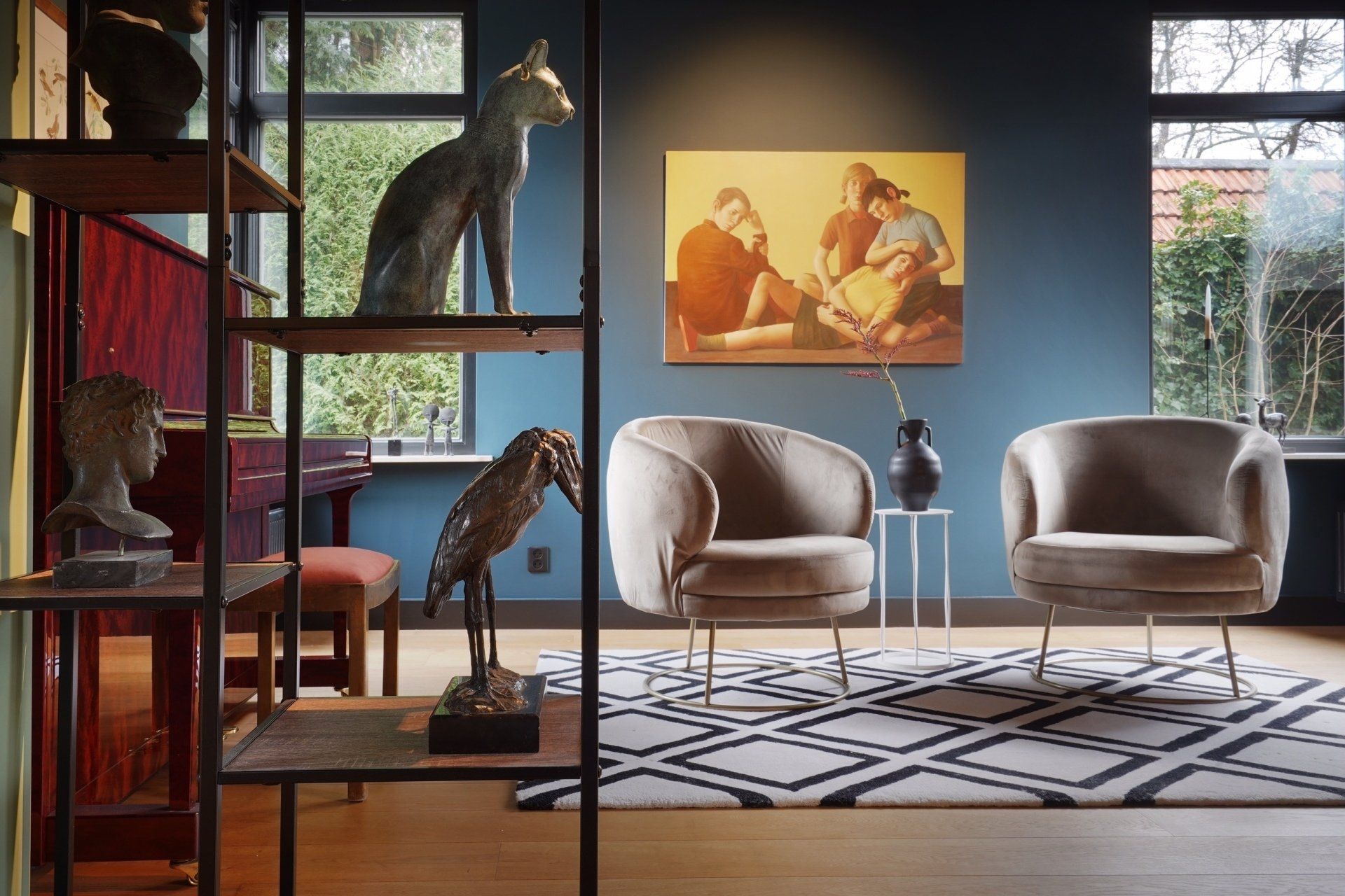 Een woonkamer met twee stoelen en een schilderij aan de muur