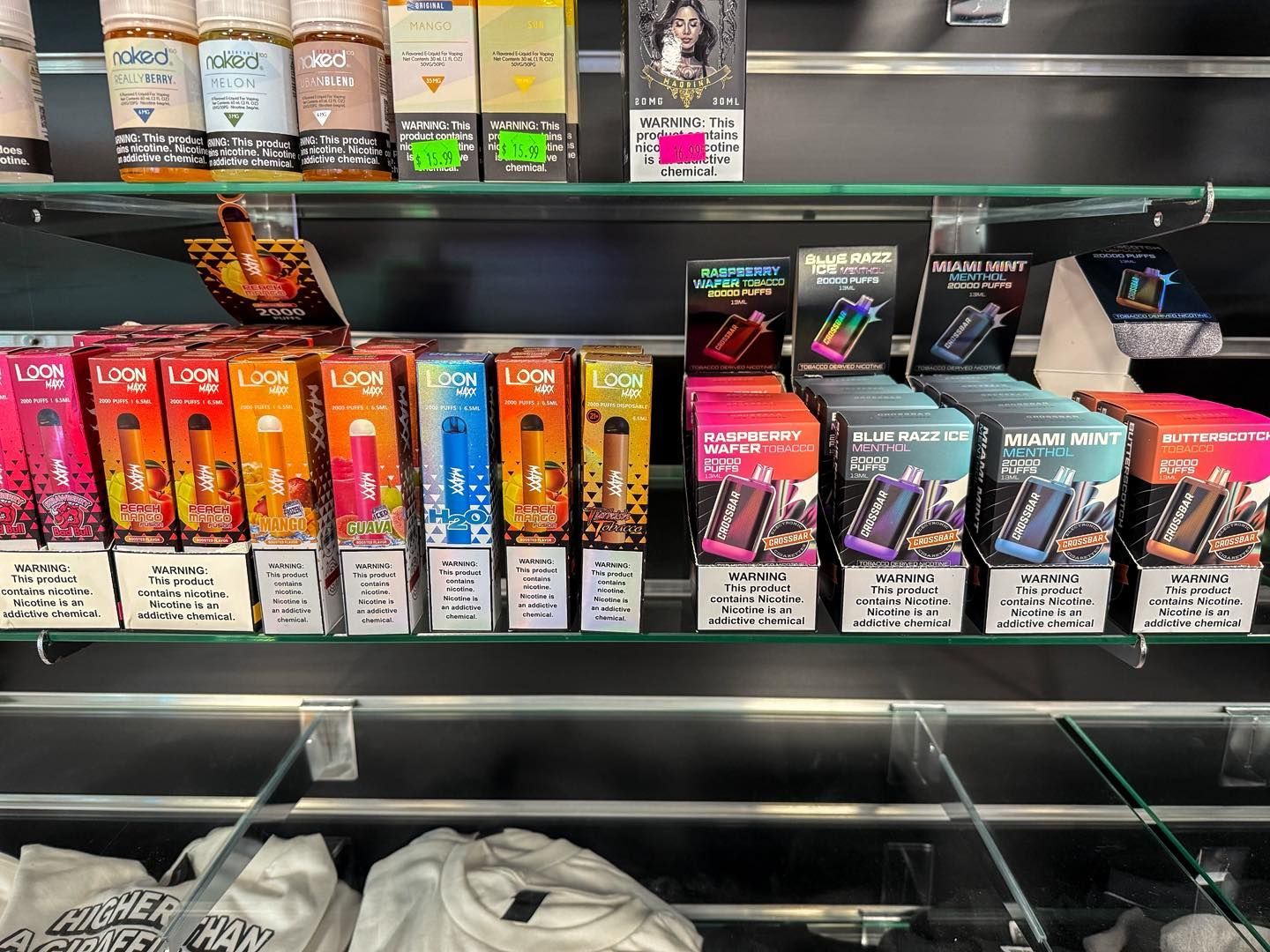 A store shelf displaying various colorful disposable vape device boxes arranged in rows.