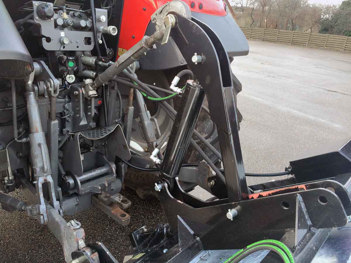 En rød og sort traktor med hydraulisk vippebeslag til tallerkenspreder