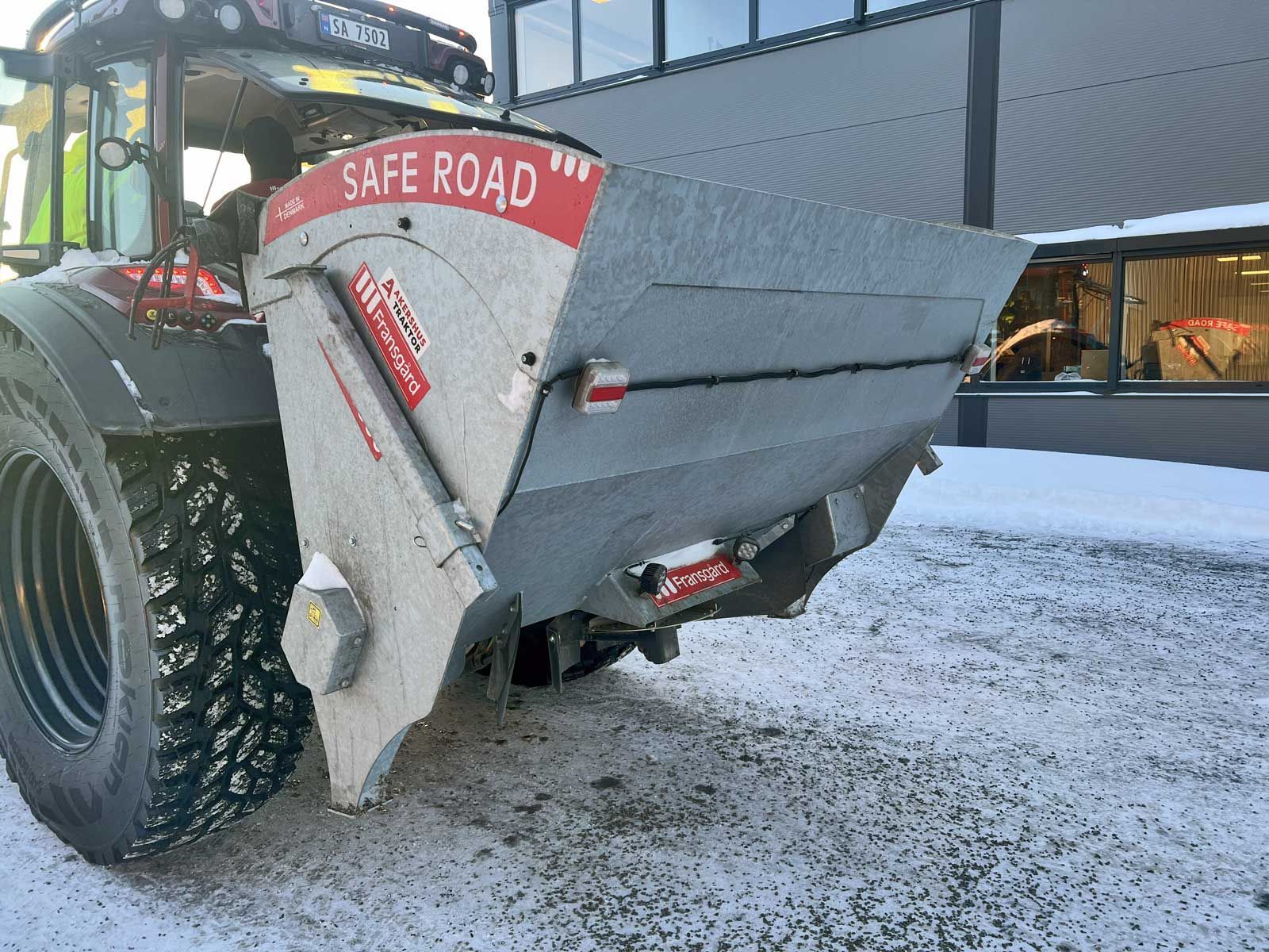 En skivespredermaskine spreder grus på plads