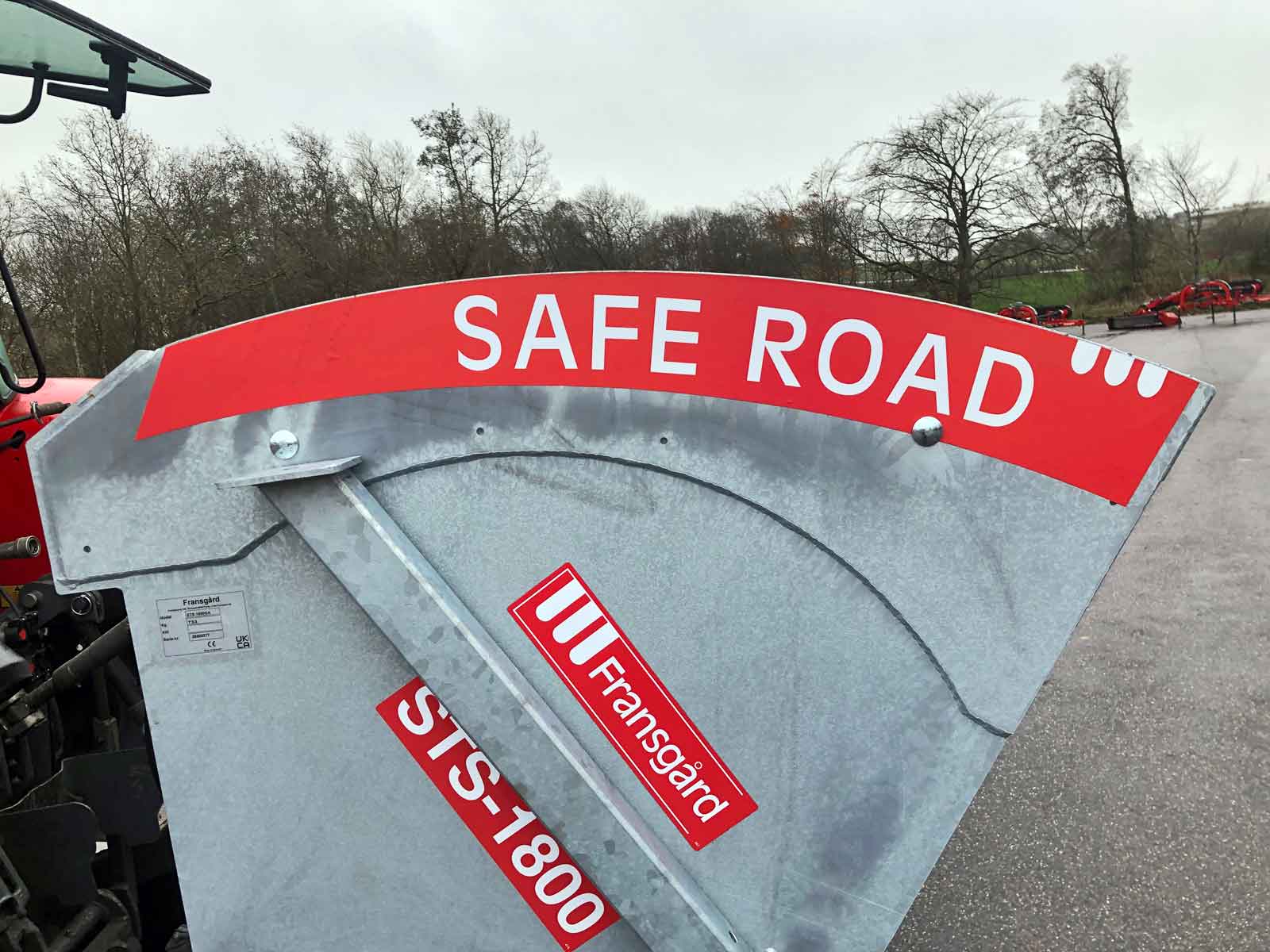 Et rødt skilt med teksten'safe road' på siden af galvaniseret tank på spredemaskine
