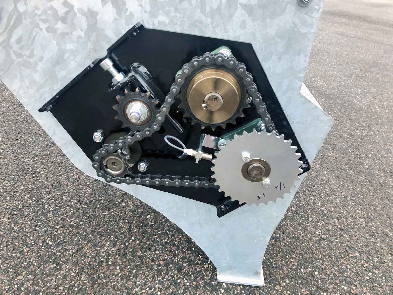 Et nærbillede af kædetræk på en maskine i galvaniseret metal