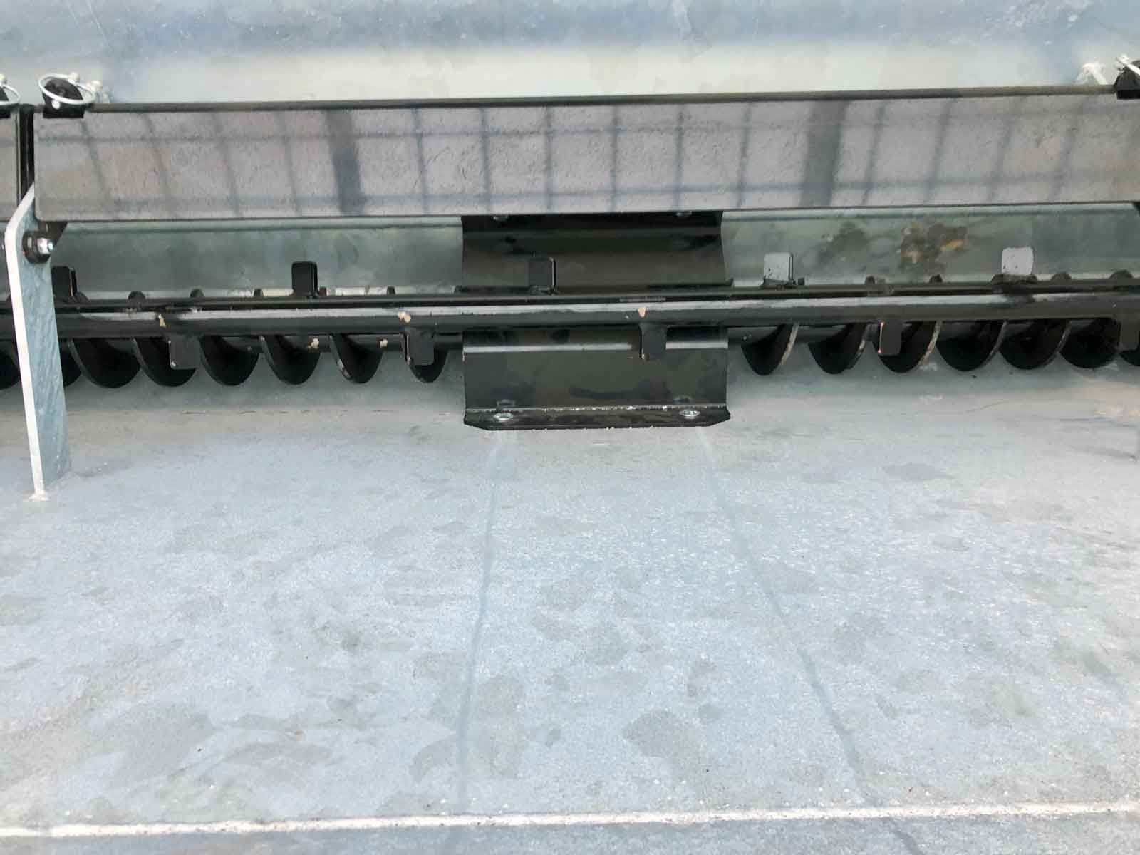 Et billede af en snegl i bunden af galvaniseret tank på materialespreder