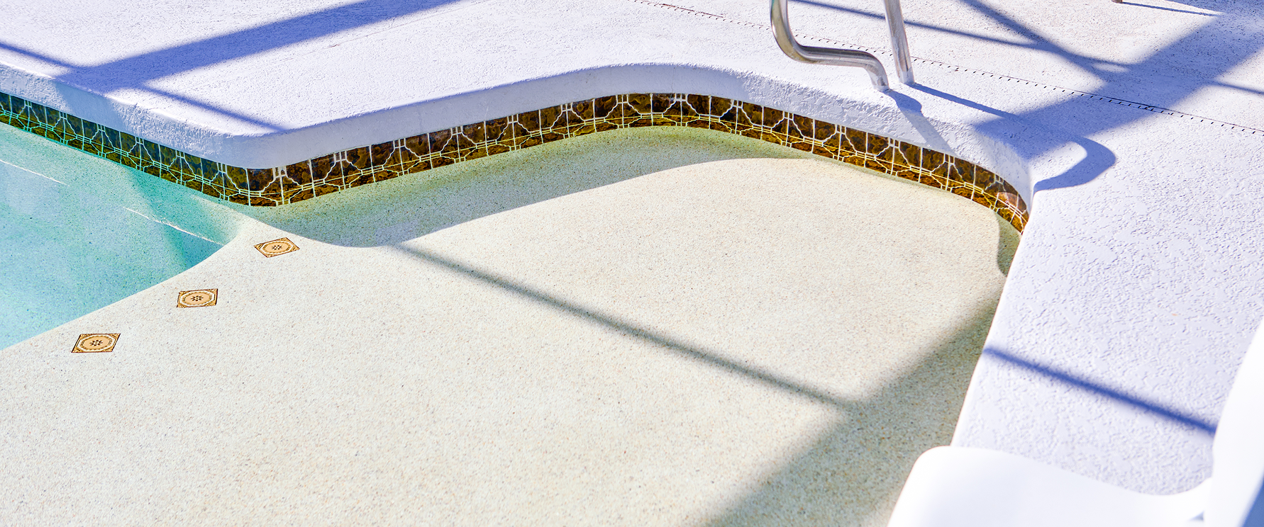 Snow-covered outdoor pool with a curved blue edge and a thin line of debris along the rim