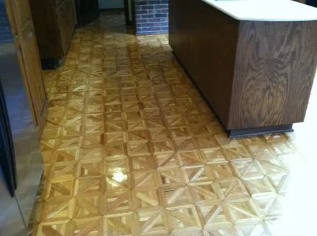 Wood-patterned vinyl floor in a narrow hallway beside a brown countertop or cabinet.