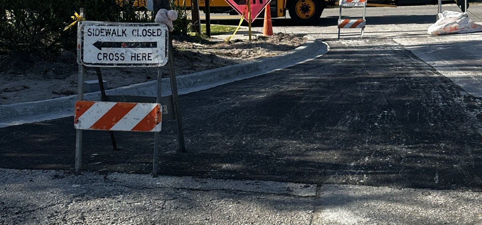 A sign that says walk closed is sitting on the side of a road.