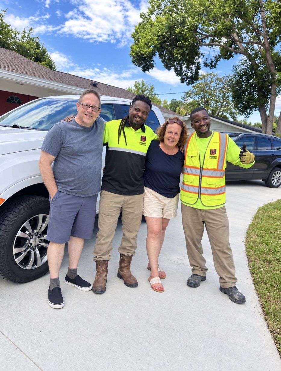 Two Concrete Renovations personnel pose in a photo with two customers smiling