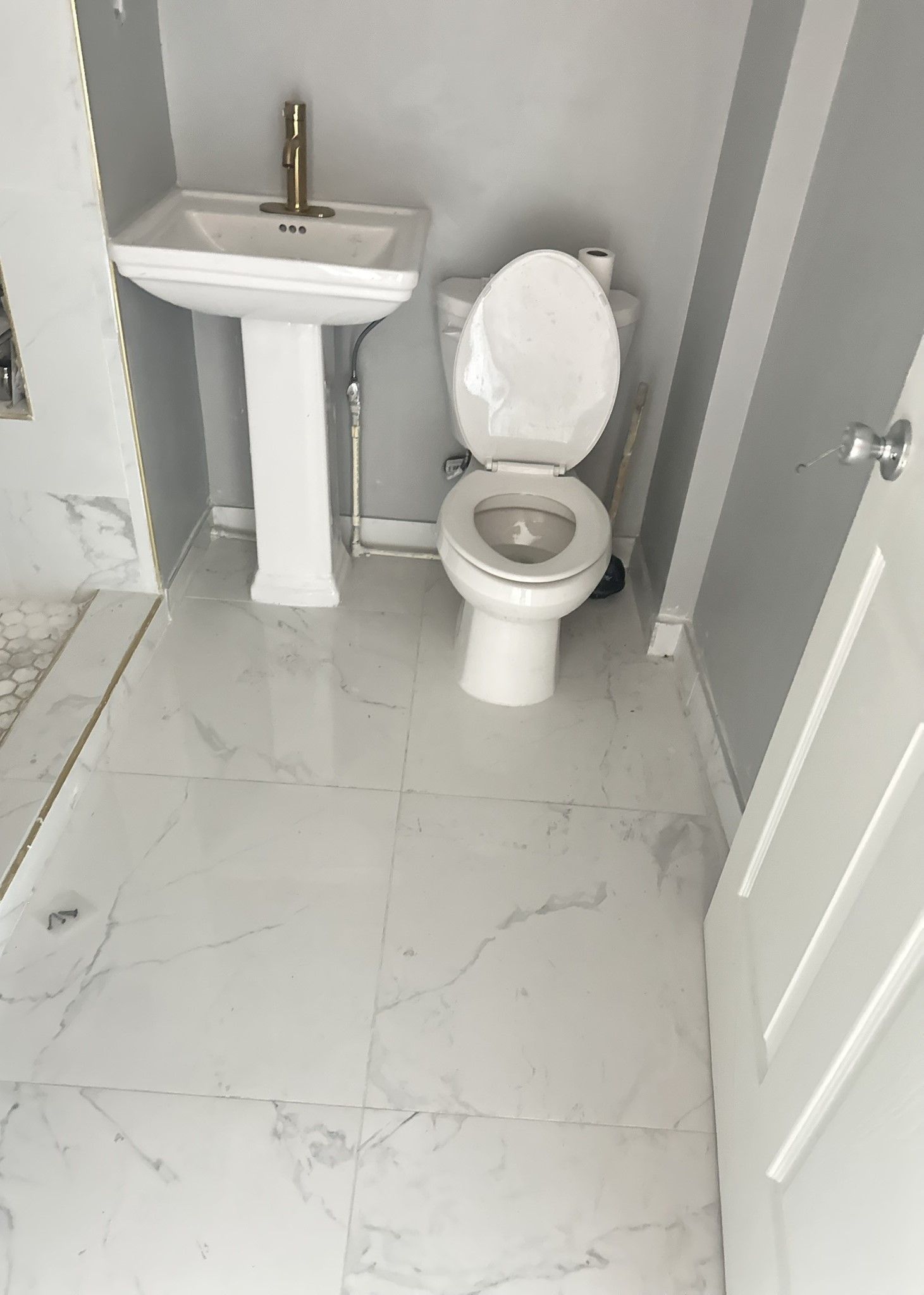 A bathroom with tile, a toilet , sink and shower.