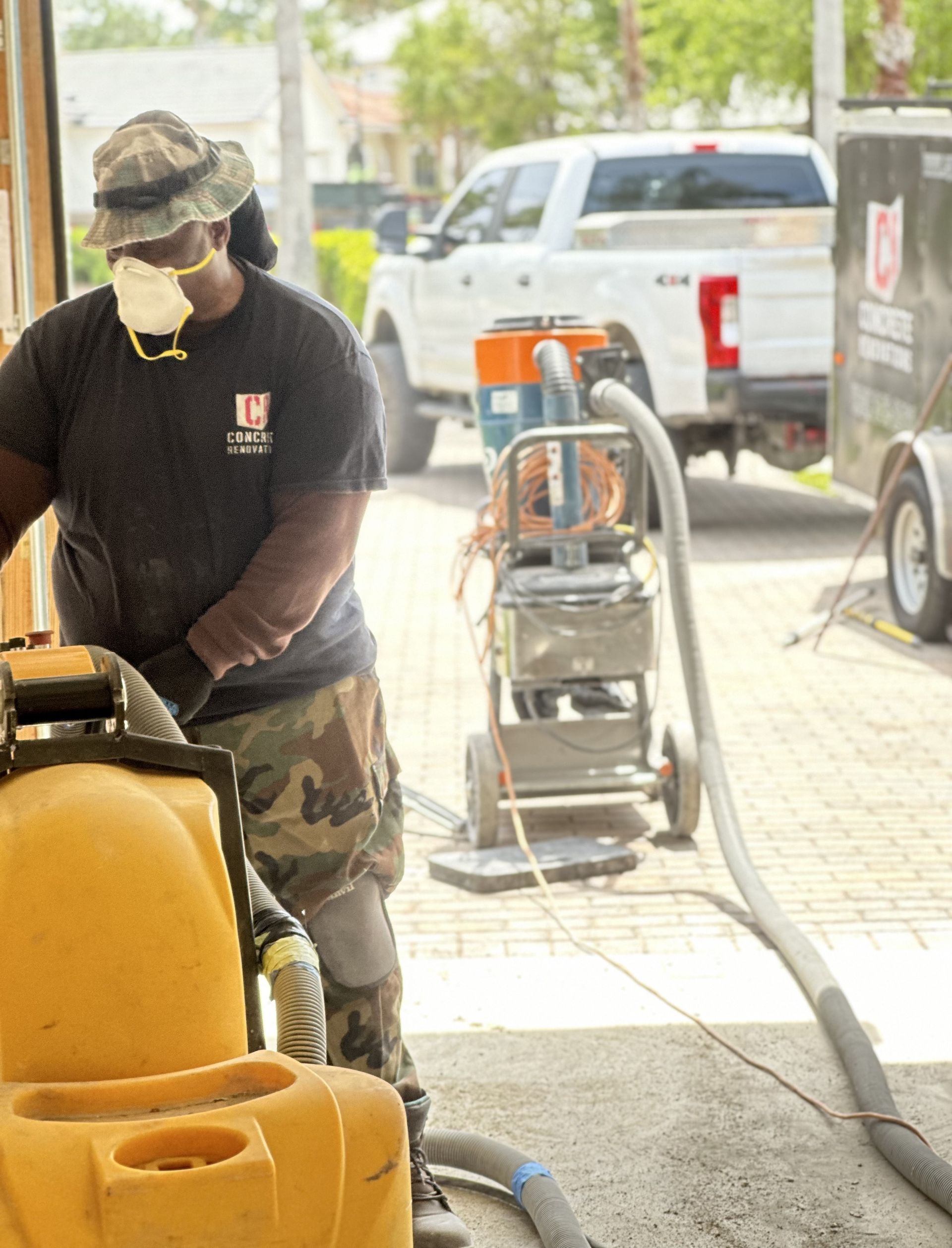 A man wearing a mask is using a concrete grinder