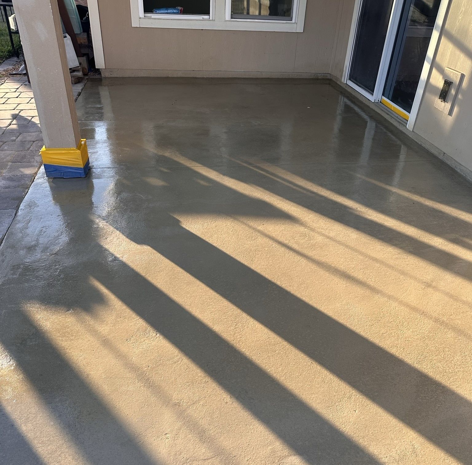 A shadow of a person is cast on a concrete floor