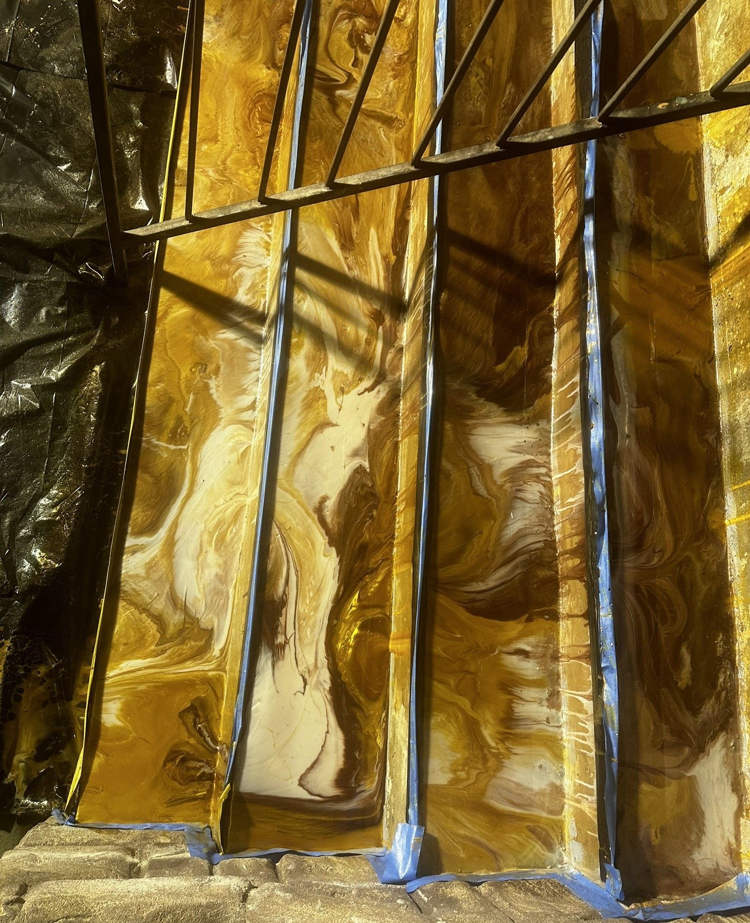 Gold metallic epoxy with dark shadows, creating a reflective abstract pattern.