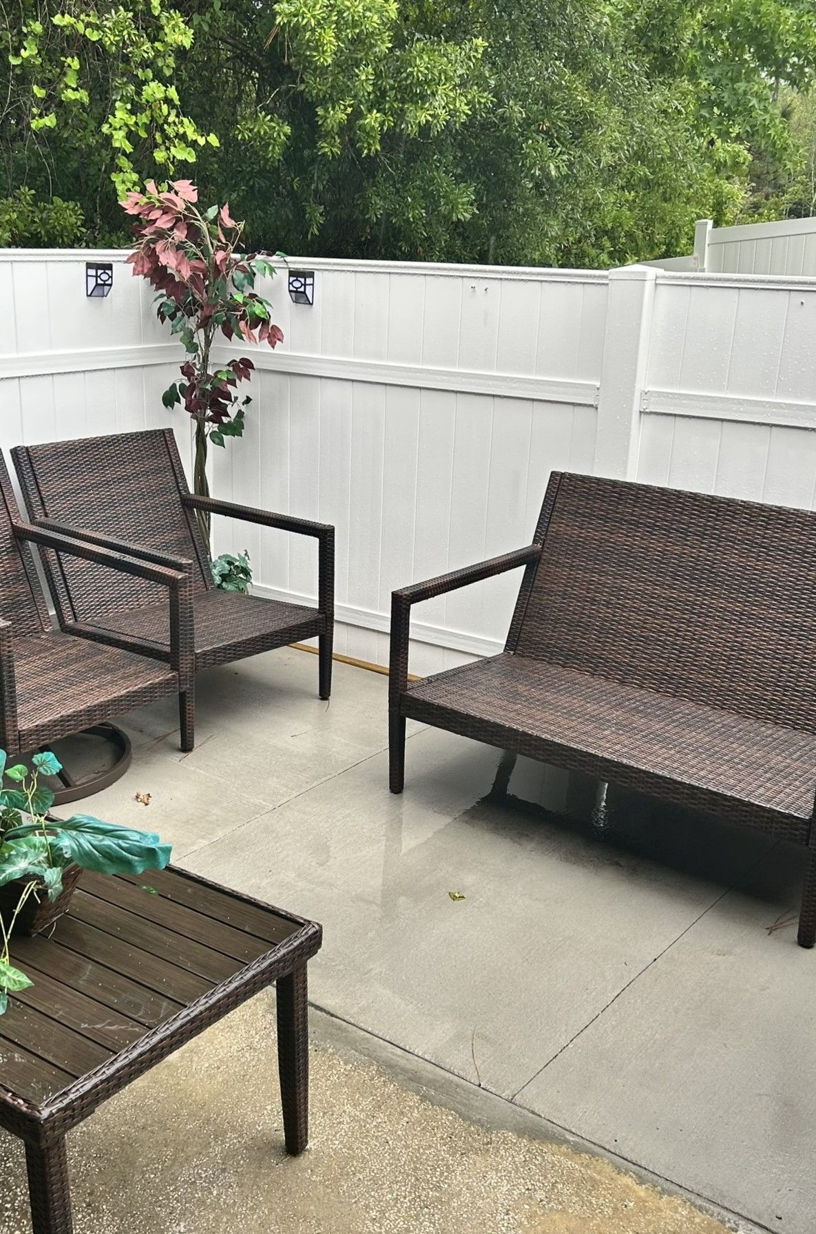 There are two chairs and a table on the patio.