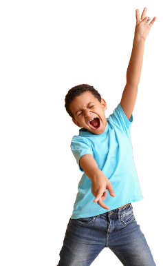 Child in a blue shirt and jeans posing energetically with one arm raised and mouth open against a white background