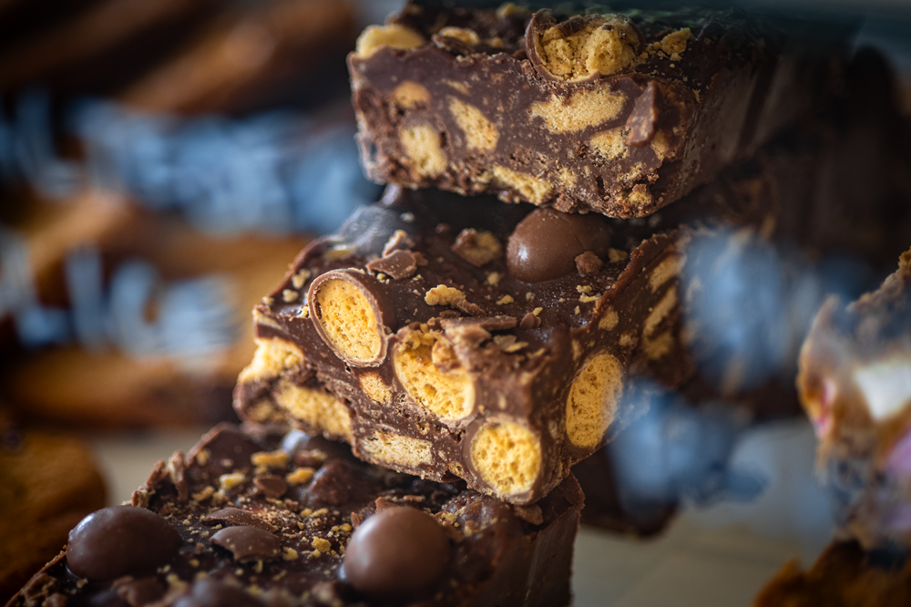 Chocolate fudge with honeycomb and biscuit pieces, stacked close-up.