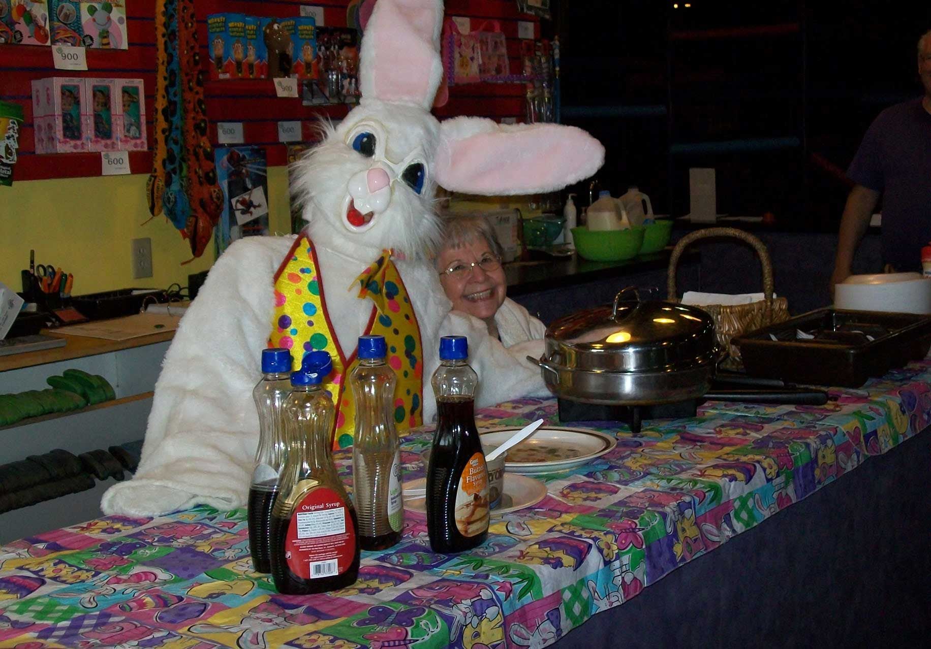 A person dressed as an easter bunny sitting at a table