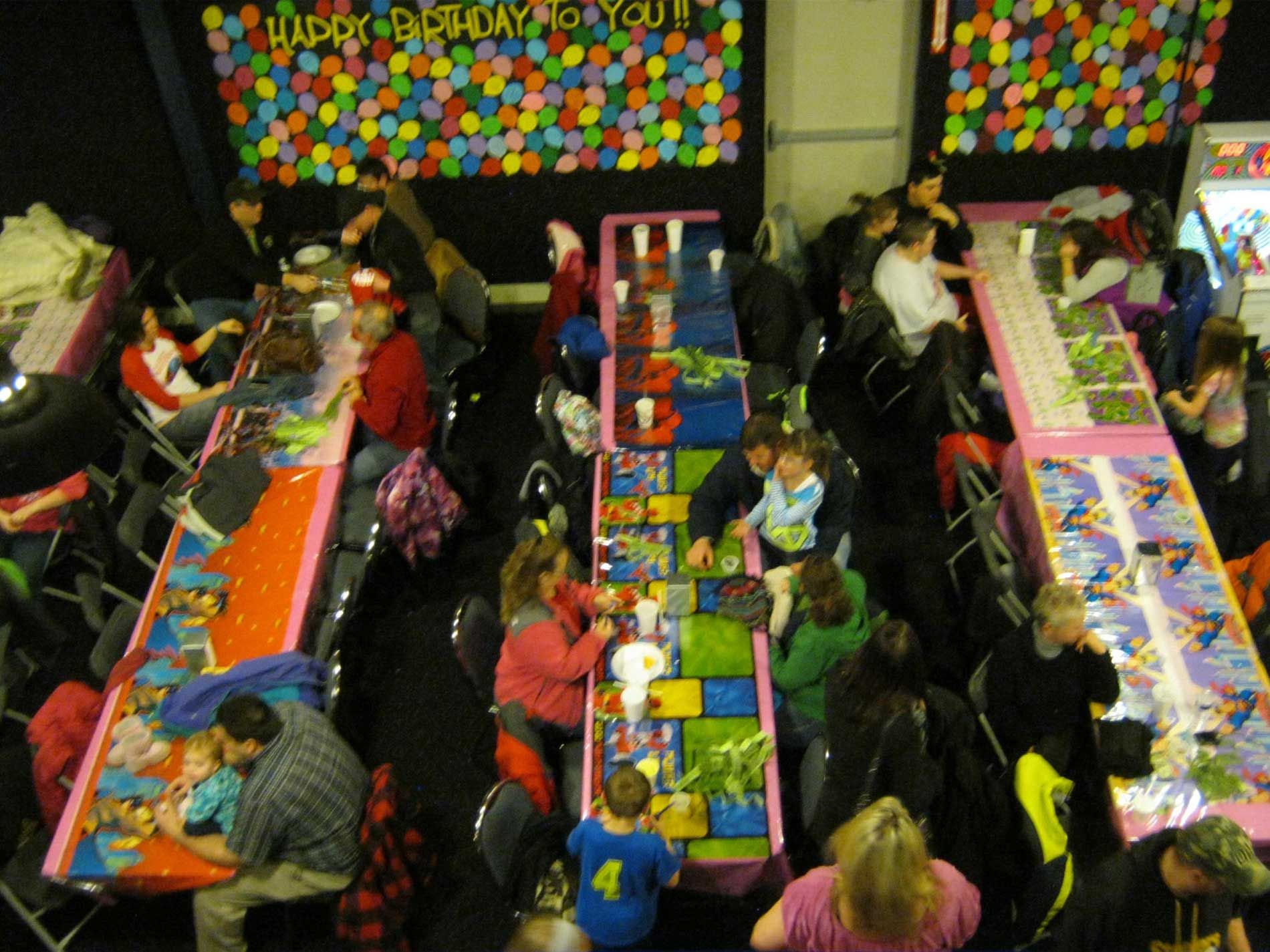 An aerial view of a birthday party with a sign that says happy birthday to you