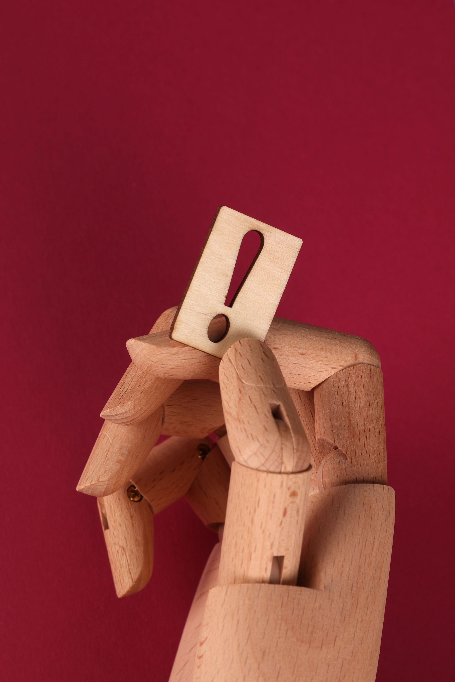 Google Ads: Wooden mannequin with a paper exclamation mark over its face against a red background
