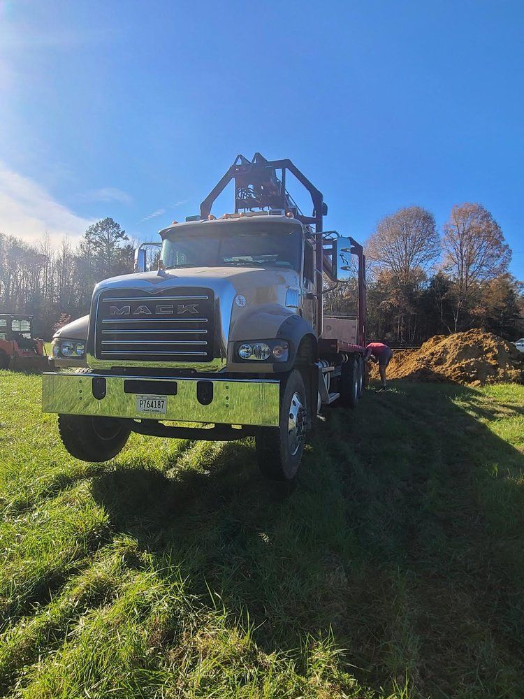 A large truck is parked in a grassy field.