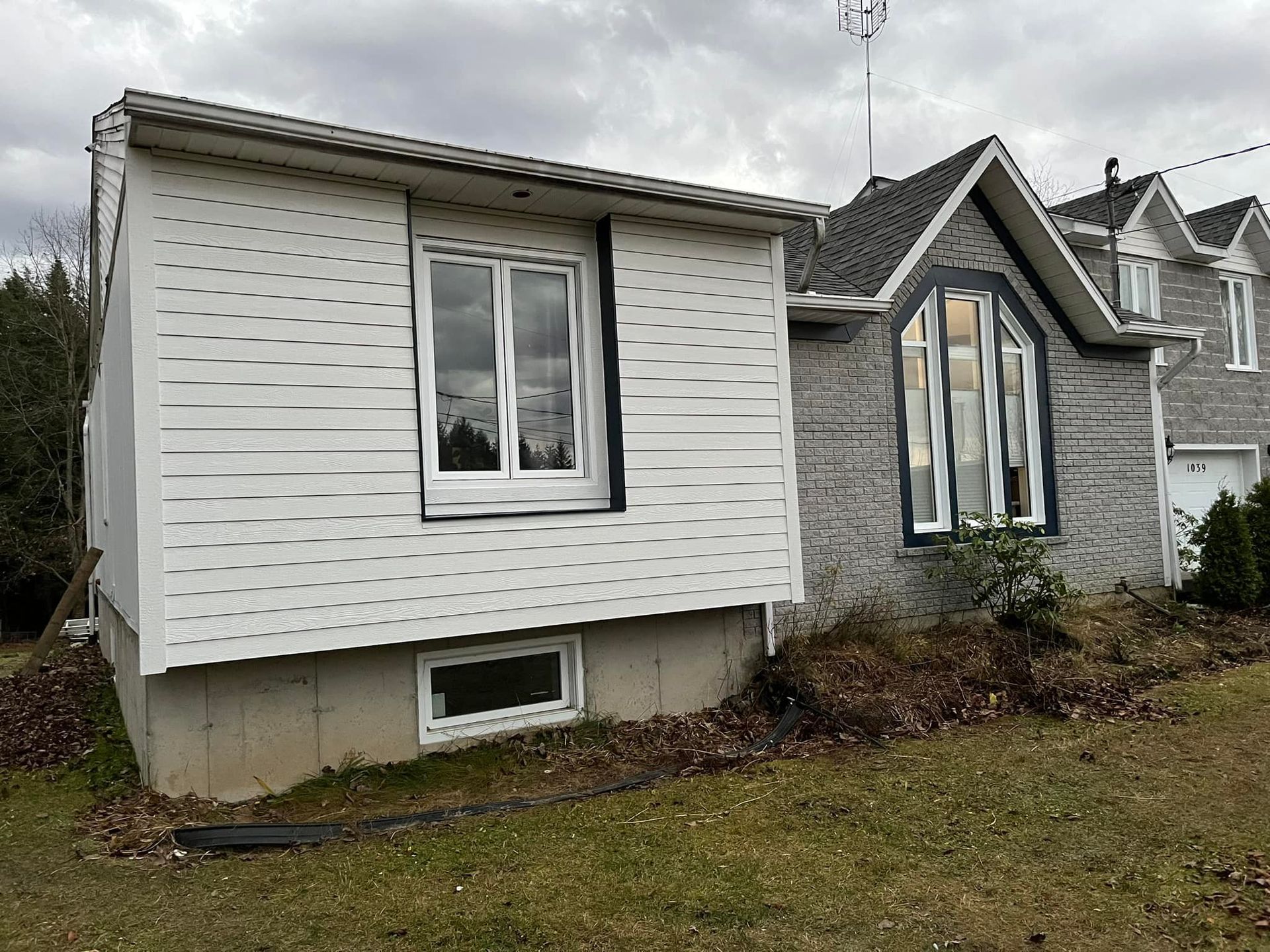 Une petite maison avec beaucoup de fenêtres et un toit.