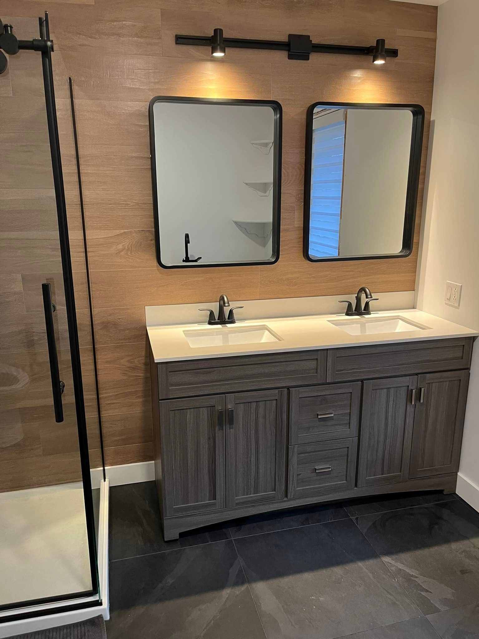 Une salle de bain avec deux lavabos et deux miroirs.