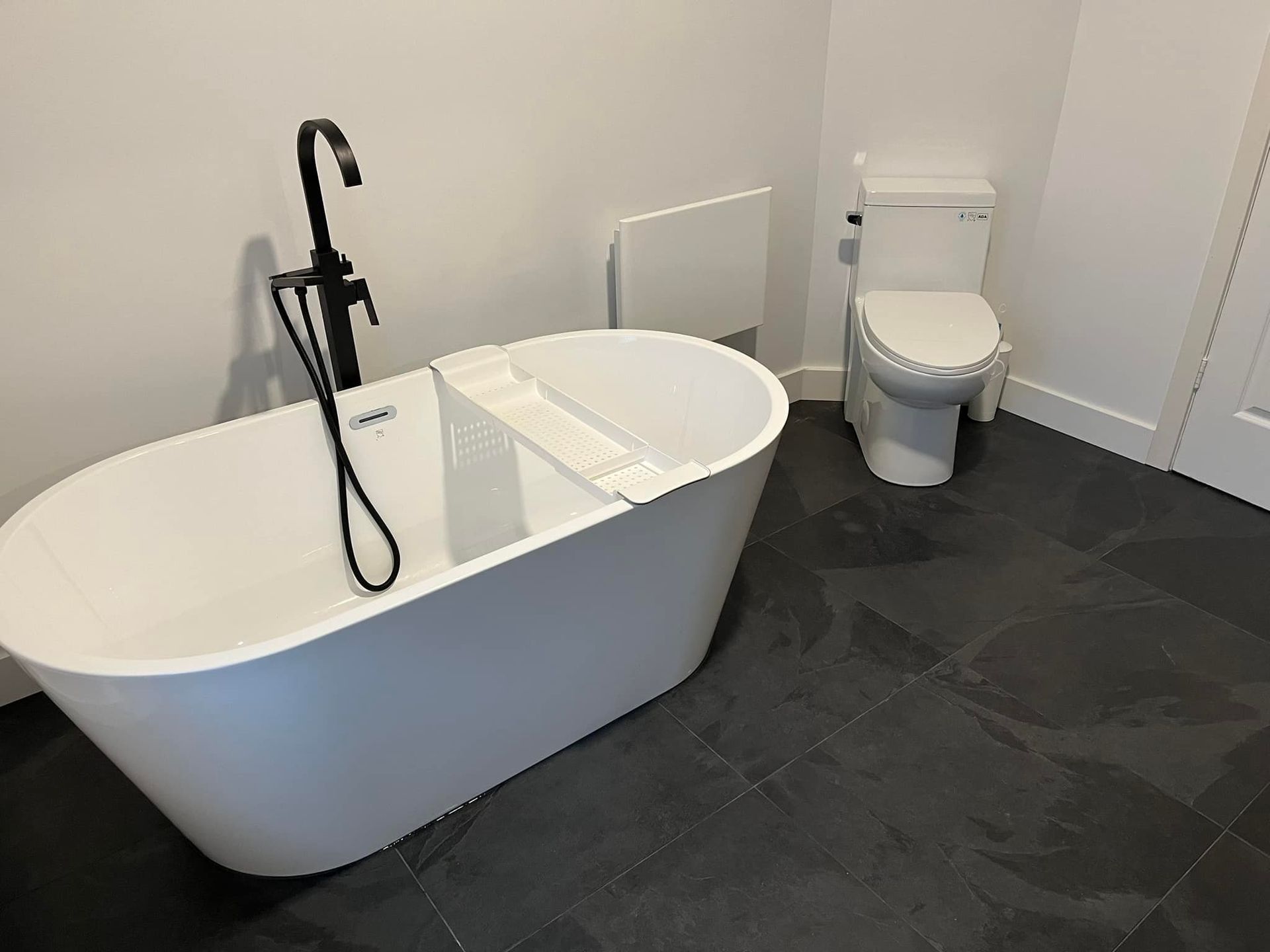 Il y a une baignoire et des toilettes dans la salle de bain.