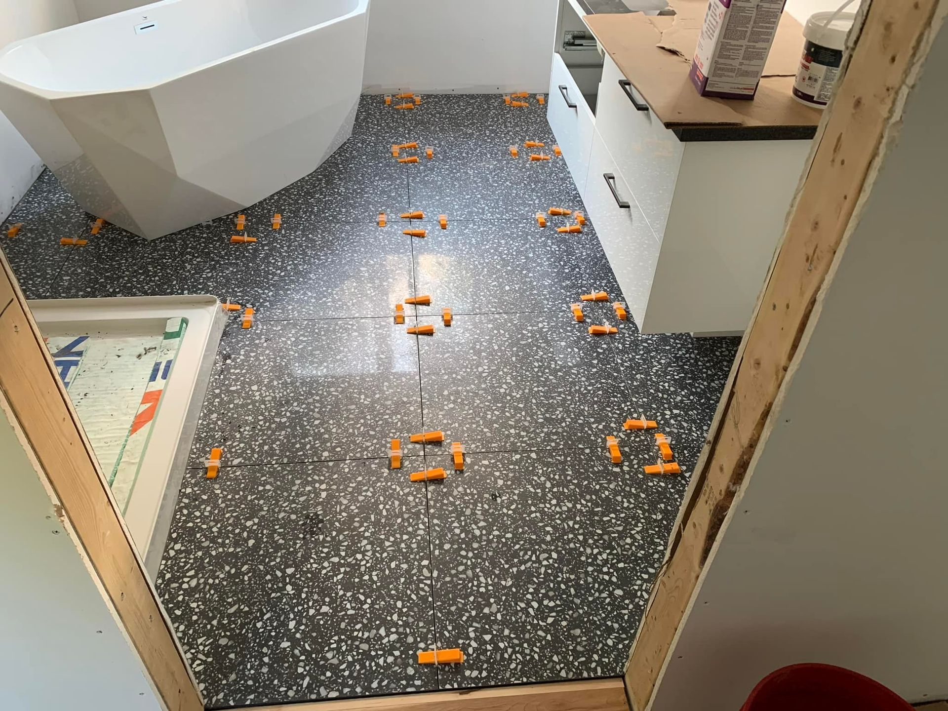 Une salle de bain avec baignoire et sol carrelé.