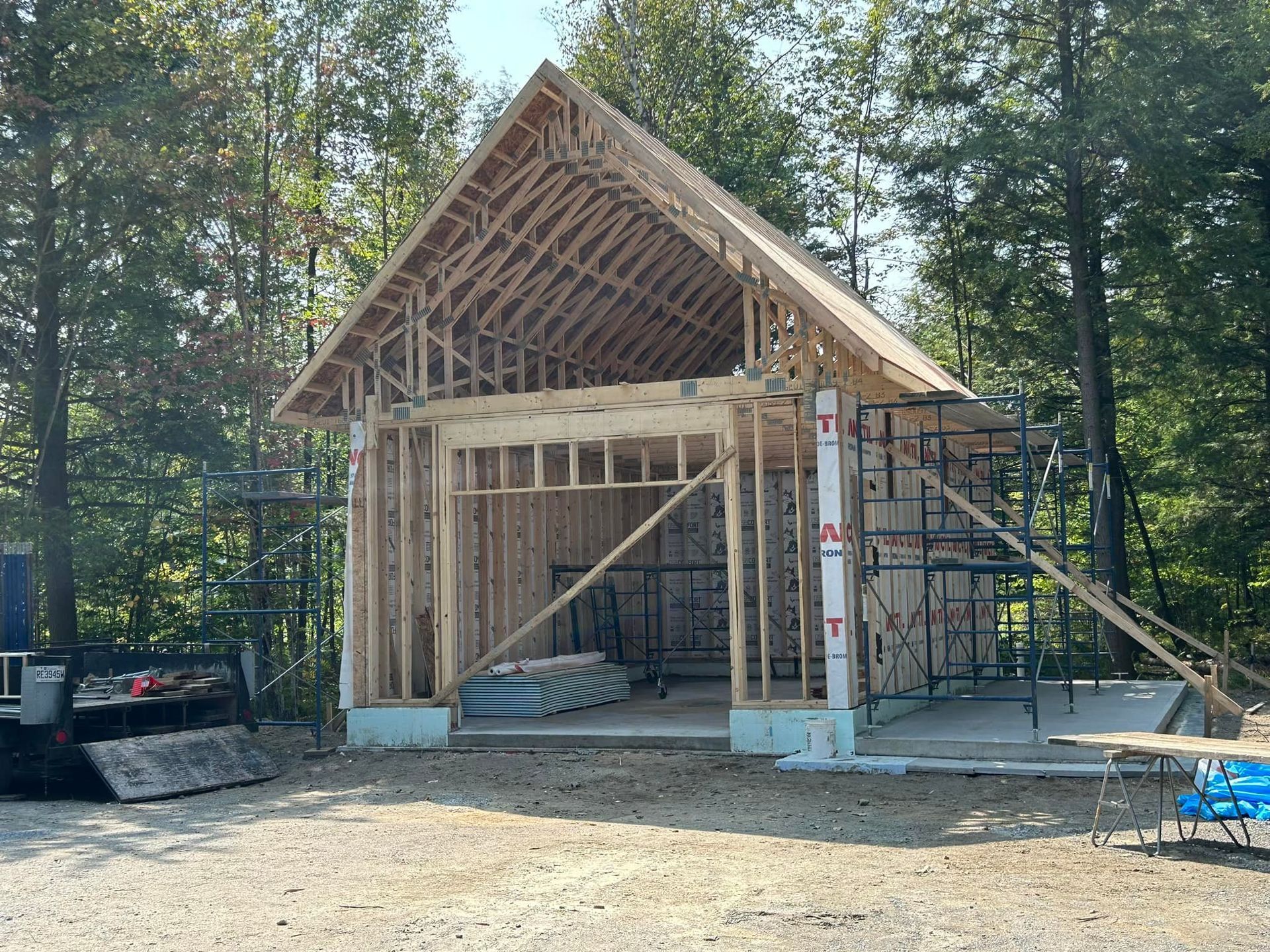 Une structure en bois est en cours de construction au milieu d'une forêt.